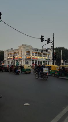 a busy city street filled with lots of traffic and people riding mopeds on the road