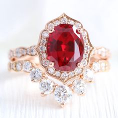 a close up view of a ring with a red stone surrounded by white and clear stones