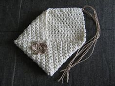 a white crocheted cloth with a brown flower on it sitting on a black surface