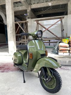 a green scooter parked in front of a building under construction with other scooters