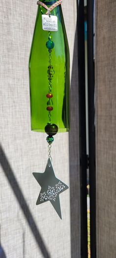 a green glass bottle with a star hanging from it