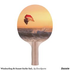 a ping pong paddle with an image of a person parasailing in the ocean