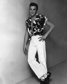 a black and white photo of a young man posing for a picture with his hands on his hips