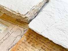 several old papers are stacked on top of each other, with writing on the paper