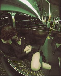 a woman sitting in the back of a bus looking at her cell phone