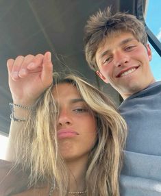 a young man and woman are posing for a photo in the back of a car