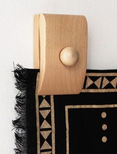 a black and white rug with a wooden button on it's end hanging from the wall