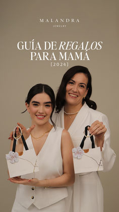 two women in white dresses holding up small bags