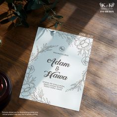 the wedding card is sitting on top of a table next to some candles and flowers