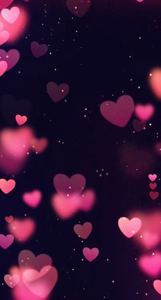 many pink hearts floating in the air on a black background with stars and sparkles