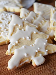 several decorated cookies sitting on top of a wooden cutting board