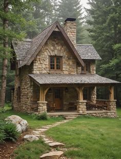 a small stone house with a porch in the woods