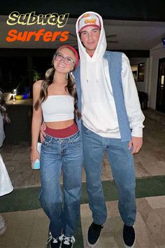 a man and woman standing next to each other in front of a surfboard shop