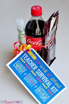 a bottle of soda and some other items on a white table with a red ribbon