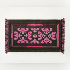 a black and pink rug hanging on a wall