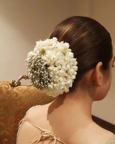 a woman with flowers in her hair sitting on a couch