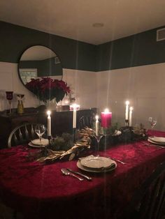 a dining room table with candles and plates on it