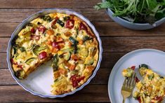 an omelet with broccoli, tomatoes and other toppings on a table