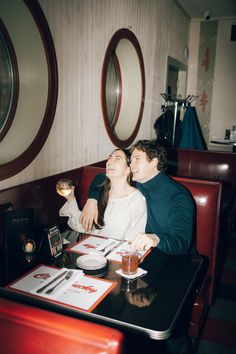 a man and woman sitting at a table with drinks