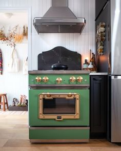 a green stove top oven sitting inside of a kitchen