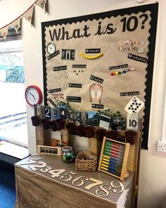 a bulletin board with lots of different things on it next to a table in front of a window