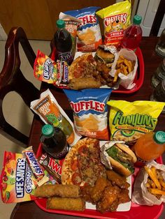 two red trays filled with different types of food and snacks on top of a wooden table