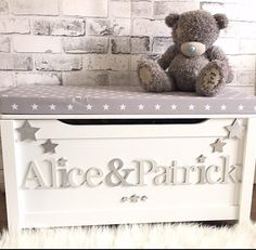 a teddy bear sitting on top of a white toy chest with the word alice and patrick written across it