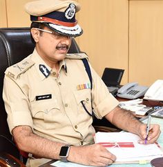 a man in uniform sitting at a desk with papers and calculator on it