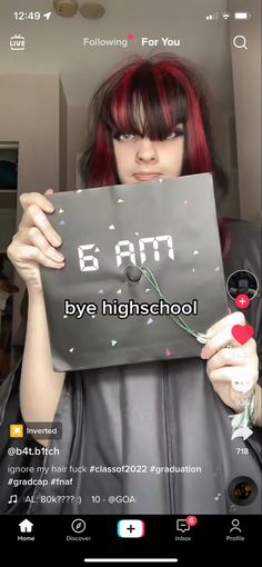 a girl with red hair holding up a sign