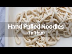 the words hand pulled noodles on a white plate