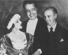 an old black and white photo of two men and a woman smiling at the camera