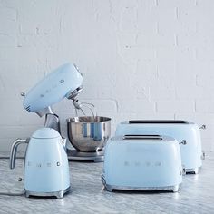 blue kitchen appliances sitting on top of a counter next to a mixer and blender