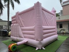 an inflatable pink tent sitting on top of a lush green field