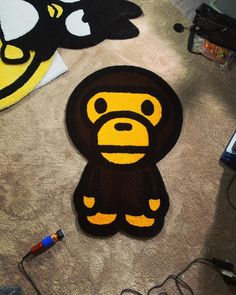 a monkey rug is on the floor next to a computer mouse and headphones,