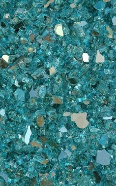 blue and gold colored glass chips that are very close together on the ground, as if they were crushed into small pieces