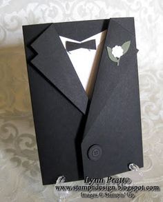 a black card with a tuxedo on it and a white rose in the lapel