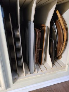 there are many plates and pans in the cabinet together, all stacked on top of each other