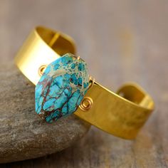 Not only does the Handmade Turquoise & Gold Cuff Bangle look great and make the perfect gift for someone. It will help you to have stress-free days and will bring you energy and wisdom Turquoise is a purification stone. Use it to dispel negative energies and protect you against pollutants or negative outside influences. It benefits the Throat Chakra with communication and expression of creativity - feeling comfortable to express your feelings - Artistically Inspired. Ancient Egyptians believed T Adjustable Turquoise Cuff Bracelet With Natural Stones, Turquoise Hand Wrapped Cuff Bracelet, Turquoise Natural Stone Cuff Bangle, Handmade Turquoise Bangle For Gift, Turquoise Bangle Cuff Bracelet With Natural Stones, Turquoise Hand-wrapped Jewelry For Meditation, Adjustable Cuff Bracelet With Natural Stones For Gift, Turquoise Cuff Jewelry For Gifts, Artisan Turquoise Bracelets For Gift