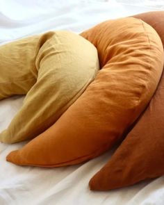 three pillows are laying on top of each other in the shape of an oval pillow