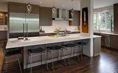 a large kitchen with an island and bar stools