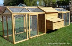 a large wooden chicken coop in the grass