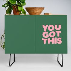 a green cabinet with the words you got this on it and a potted plant