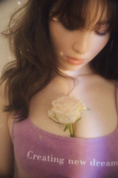 a close up of a mannequin with a rose in her chest and the words creating new dreams written on it