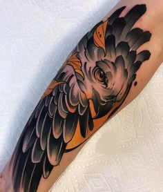 an owl tattoo on the arm with black and grey ink, sitting on top of a white sheet