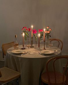 a table with plates and candles on it