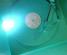 an old record player is sitting on the floor with its light shining from behind it