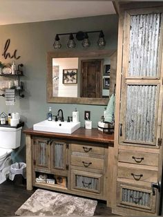 a bathroom with a toilet, sink and wooden cabinetry in it's center