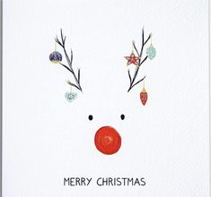 a christmas card with a reindeer's nose and ornaments on it, which reads merry christmas