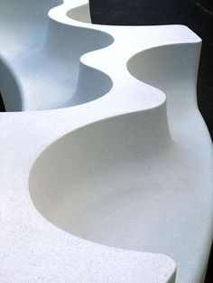 several white curved concrete sculptures on display