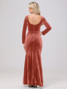 a woman in a red velvet dress with her back to the camera, looking down